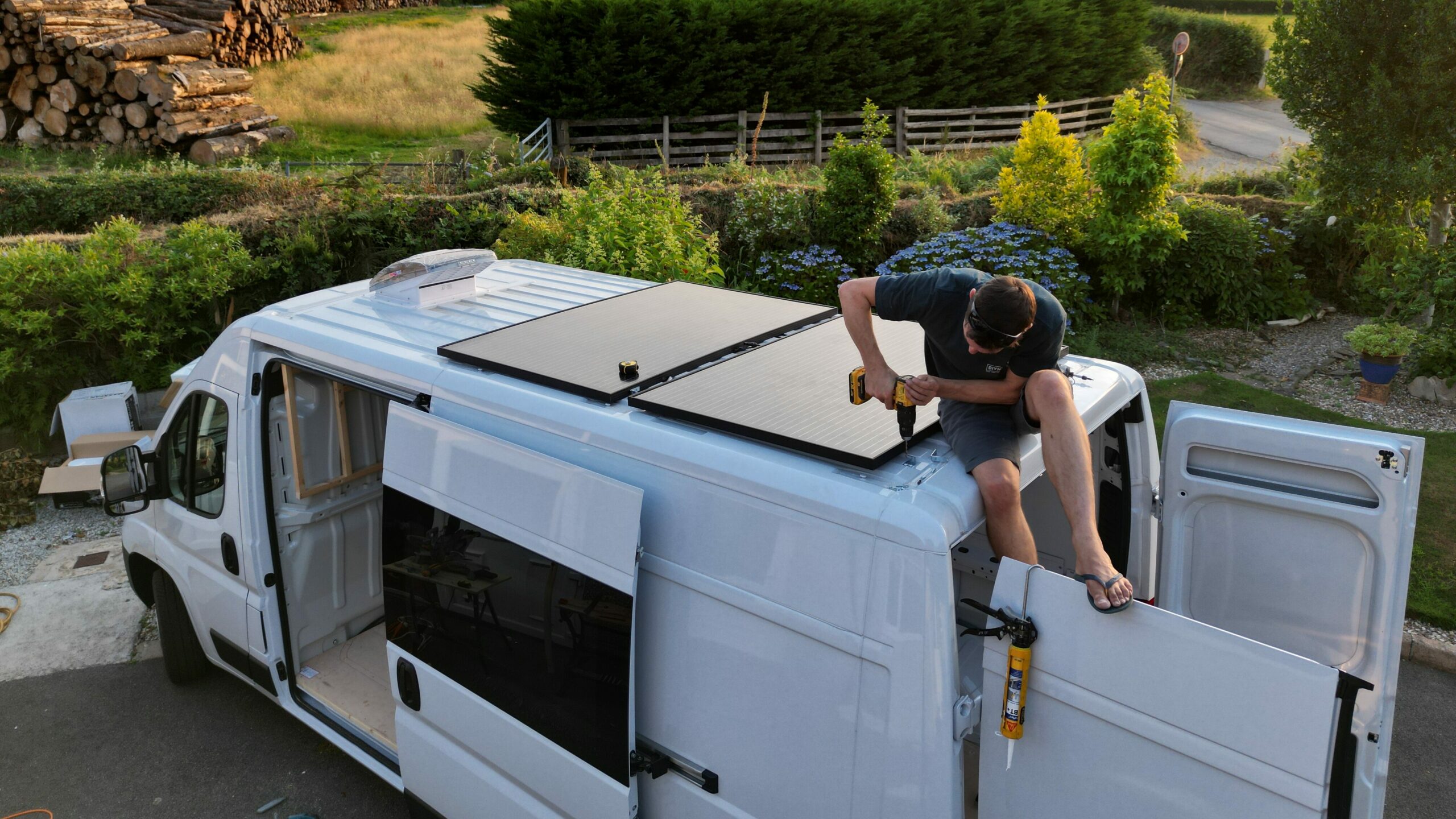 Installing solar panels on the roof of a van conversion.